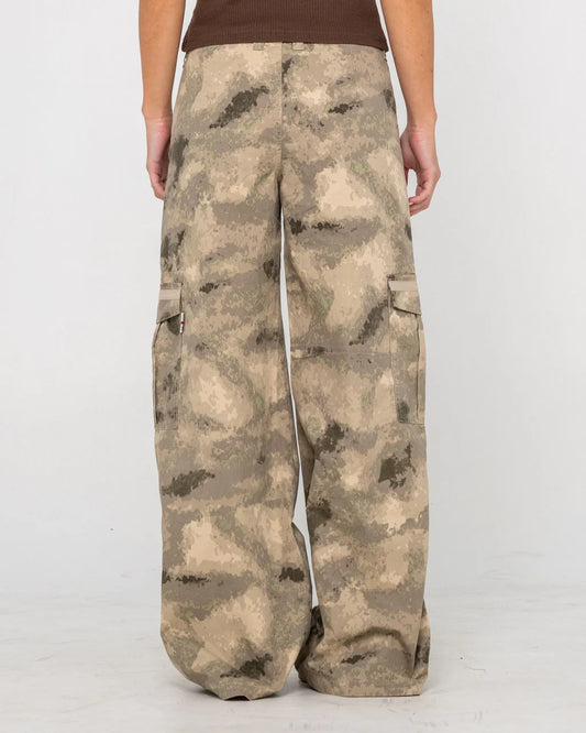 Camouflage pants worn by a person on a white background