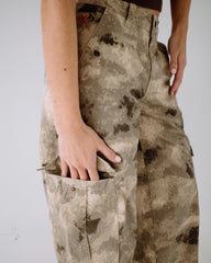 Camouflage pants with dirt stains on a plain background