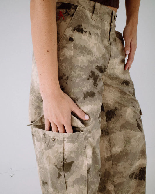 Camouflage pants with dirt stains on a plain background