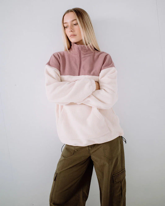 Person wearing a two-tone fleece jacket with a plain background