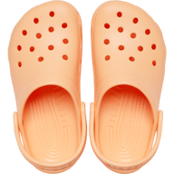 Pair of peach-colored clogs with red dots on a white background