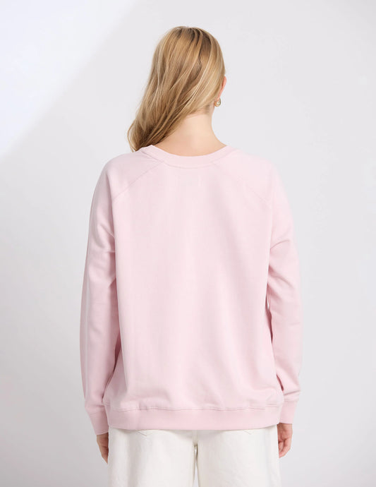 Person wearing a light pink sweatshirt on a white background
