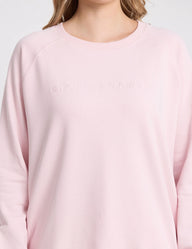 Pink sweatshirt with brand logo on a light gray background
