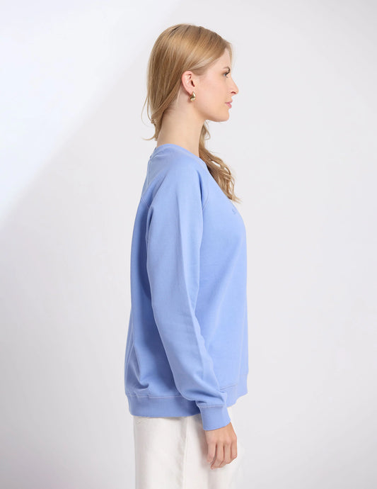 Woman wearing a light blue sweatshirt on a white background