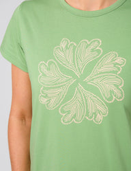 Green t-shirt with a white floral design on a plain background
