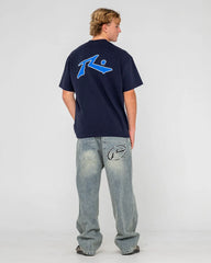 Person wearing a navy blue t-shirt with a logo on a light gray background