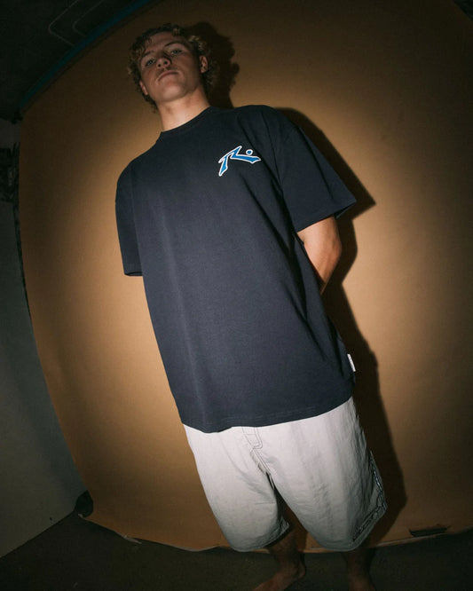 Person wearing a navy t-shirt with a logo against a plain background