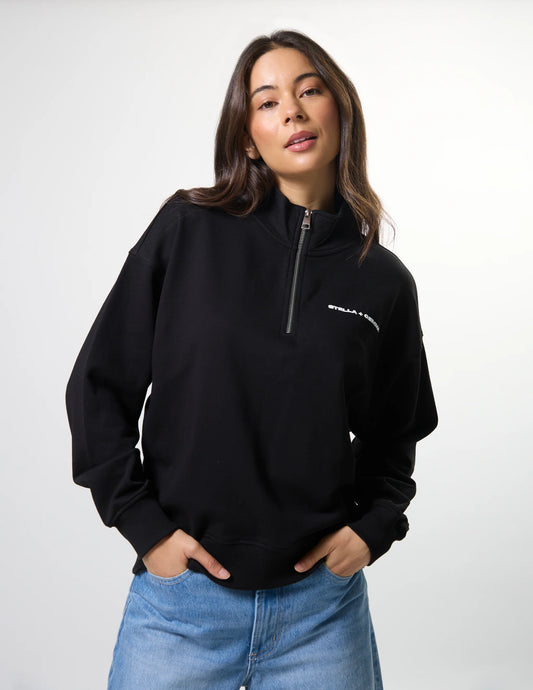 Woman wearing a black quarter-zip sweatshirt with a logo on a white background