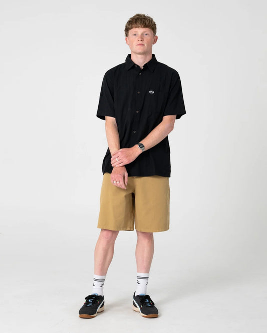 Person wearing a black shirt and beige shorts on a white background