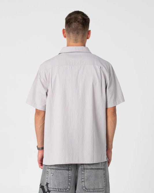Man wearing a light gray short-sleeve shirt on a white background
