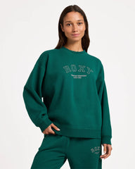 Person wearing a green Roxy sweatshirt and pants on a white background