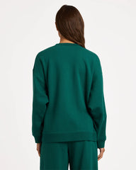 Person wearing a green sweatshirt and pants on a white background