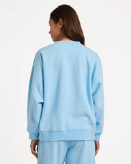 Person wearing a light blue sweatshirt and pants on a white background