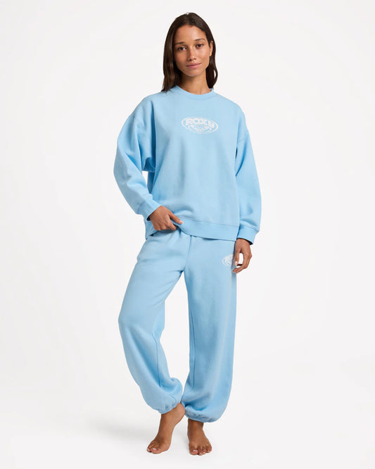 Person wearing a light blue sweatshirt and pants set on a white background
