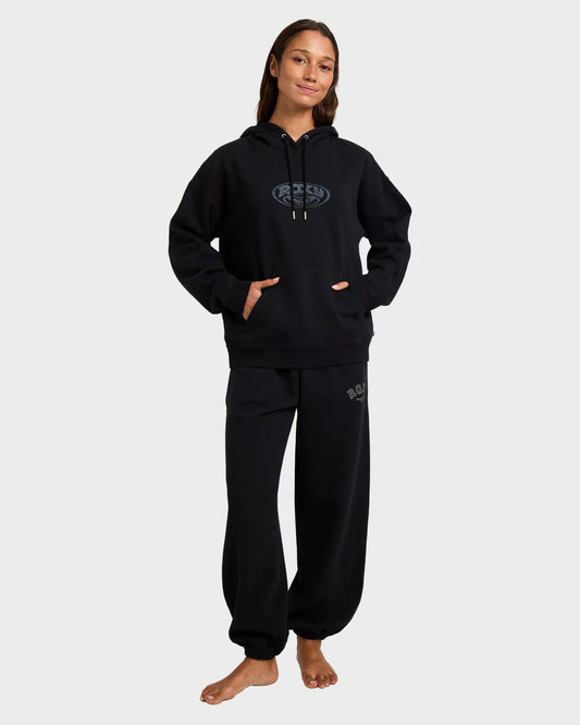 Person wearing a black hoodie and pants set on a white background