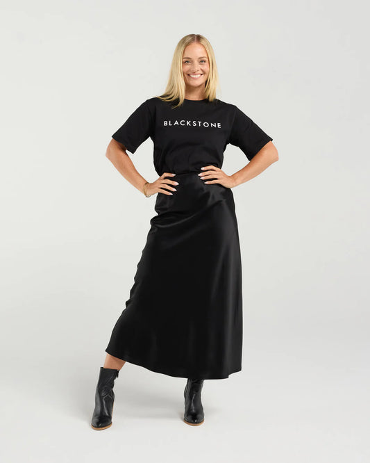 Woman wearing a black 'Blackstone' t-shirt and black skirt on a white background