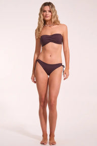 Woman wearing a brown bikini set on a white background