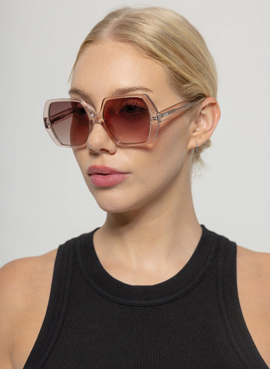Woman wearing large sunglasses with a plain background