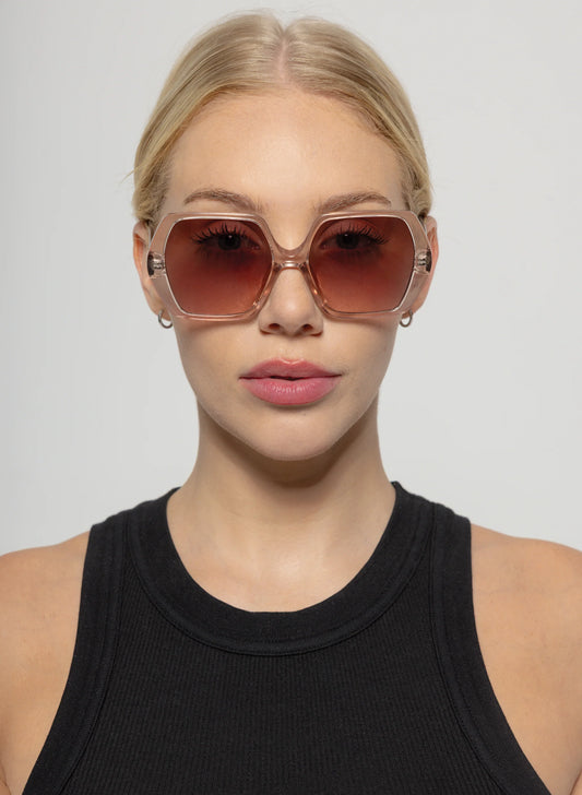 Woman wearing large sunglasses with a plain background
