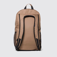 A tan canvas backpack shown from the back, featuring black padded shoulder straps, side mesh pockets, and a top carry handle, set against a light gray background.