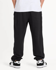 Person wearing black pants and white sneakers on a white background
