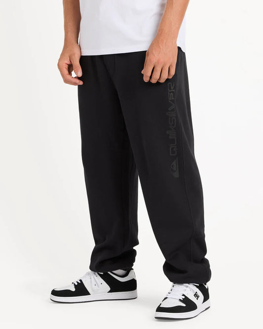 Person wearing black pants with a brand logo on a white background