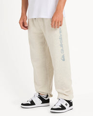 Person wearing beige sweatpants with a brand logo and black and white sneakers on a white background