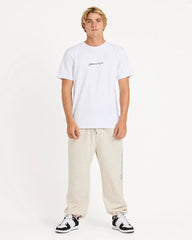 Person wearing a white t-shirt and beige pants on a plain background