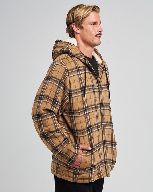 Man wearing a brown plaid jacket on a gray background