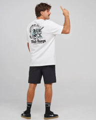 A man wearing a white t-shirt with a large black and blue graphic on the back, paired with black shorts, socks, and sneakers, standing against a light gray studio background.