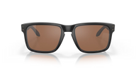 Sunglasses with a black frame and brown lenses on a reflective surface