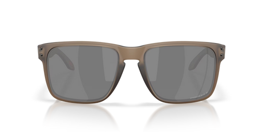 A pair of square-frame sunglasses with a matte taupe-brown frame and dark gray lenses, shown against a clean white background with a subtle reflection.
