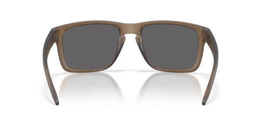 A pair of square-frame sunglasses with a translucent taupe-brown frame and dark gray lenses, shown from the front on a white background with a soft reflection.