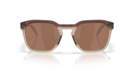 Sunglasses with brown lenses and gold frame on a reflective surface