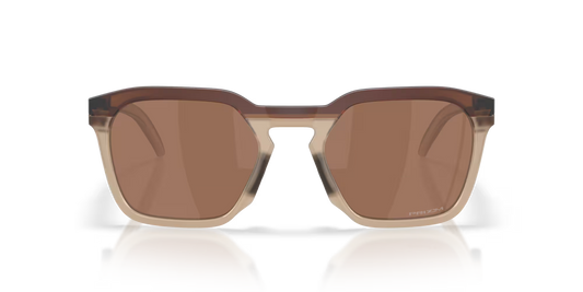 Sunglasses with brown lenses and gold frame on a reflective surface