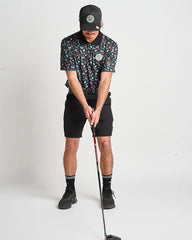 Person in golf attire holding a golf club on a white background
