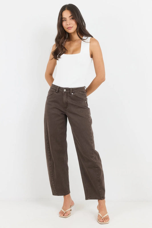 Woman wearing brown pants and a white tank top on a white background