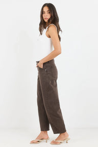 Woman wearing brown pants and a white top on a white background