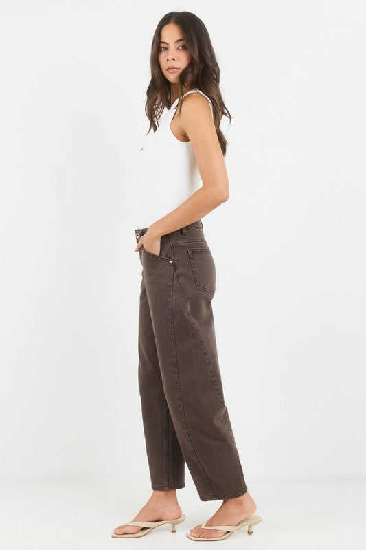 Woman wearing brown pants and a white top on a white background