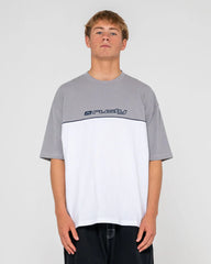 Person wearing a gray and white t-shirt with a logo on a plain background