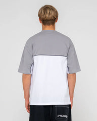 Person wearing a gray and white shirt with 'Rusty' branding on a light gray background
