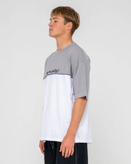 Person wearing a gray and white t-shirt with text on a plain background