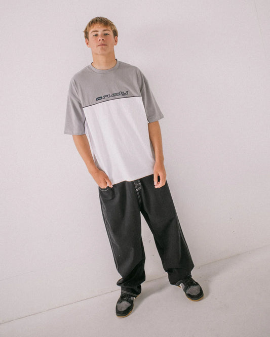 Person wearing a gray and white t-shirt with black pants on a light gray background