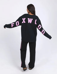 Person wearing a black outfit with pink text on a white background