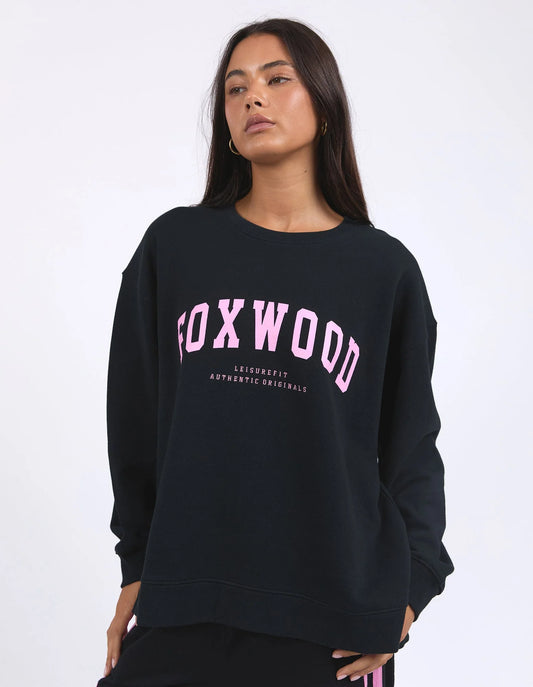 Person wearing a black sweatshirt with 'FOXWOOD' printed in pink on a white background