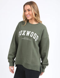Woman wearing a green sweatshirt with 'Foxwood' branding on a white background