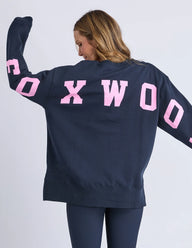 Person wearing a navy blue sweatshirt with pink text on the back against a white background
