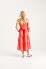 Woman wearing a coral dress on a white background