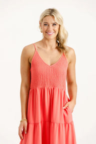 Woman wearing a coral dress on a white background