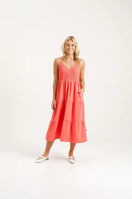 Woman wearing a coral dress on a white background